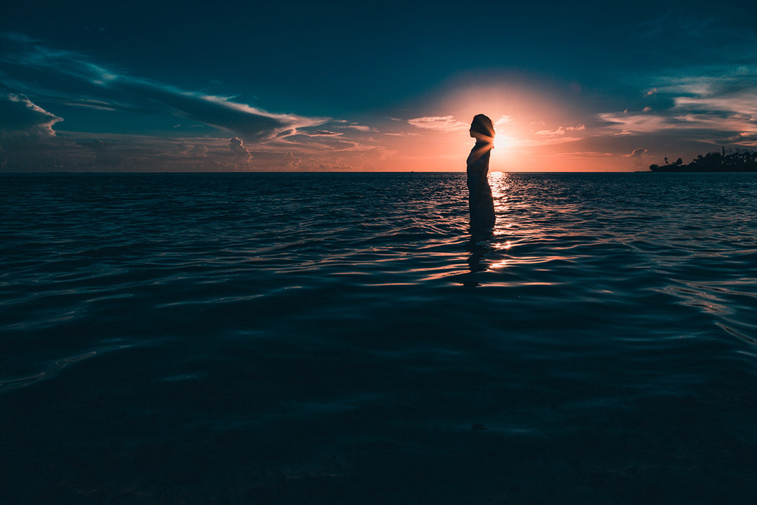 Femme devant le coucher de soleil à Matira Bora Bora