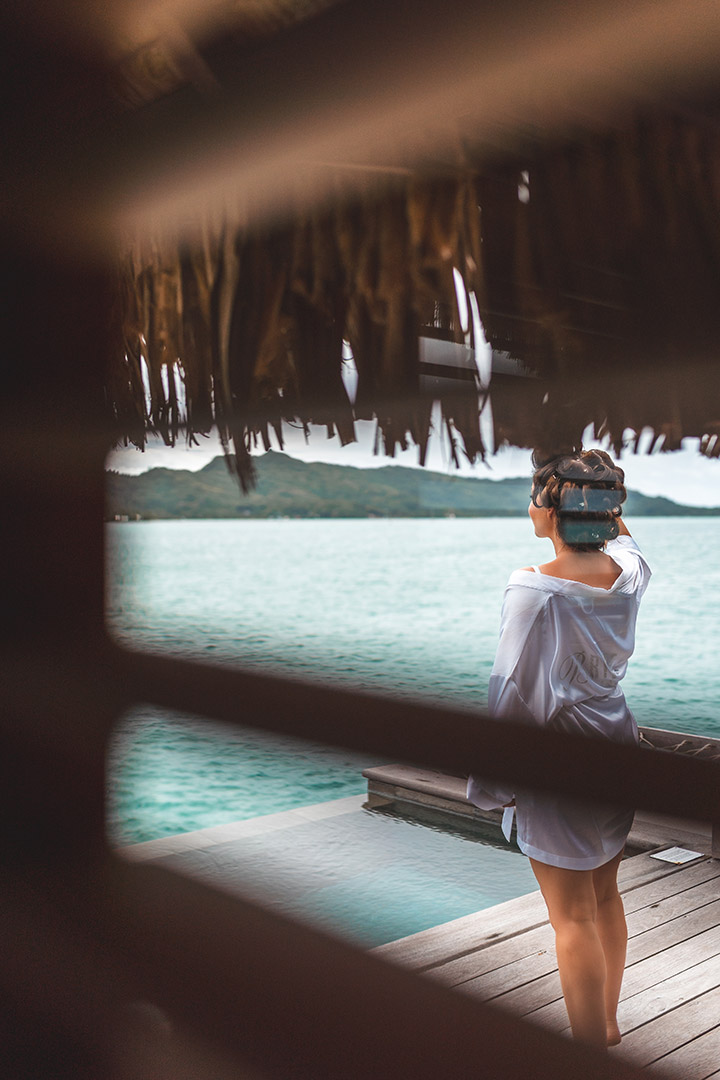 Photographe de mariage au Four Seasons Bora Bora - La mariée se prépare et regarde l'horizon depuis le ponton de sa chambre.