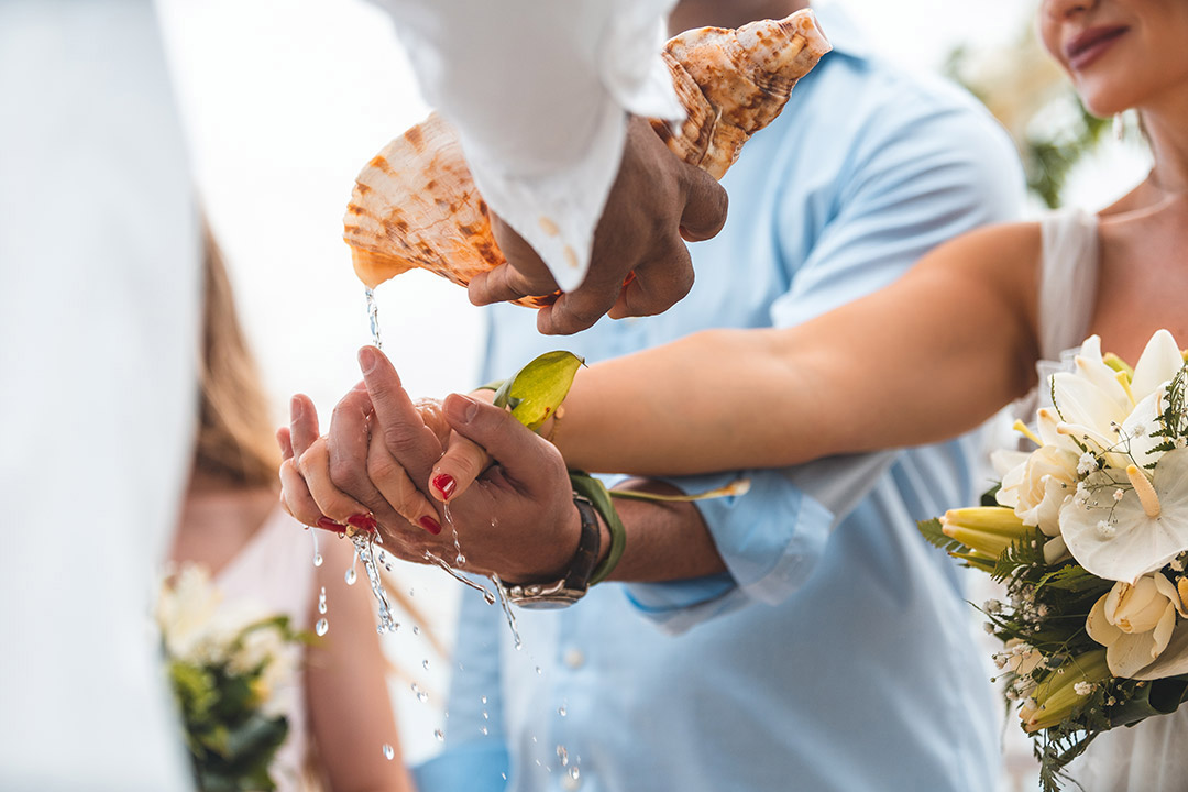 Photographe de mariage au Four Seasons Bora Bora - Image des mains pendant le versement de l'eau sacrée.