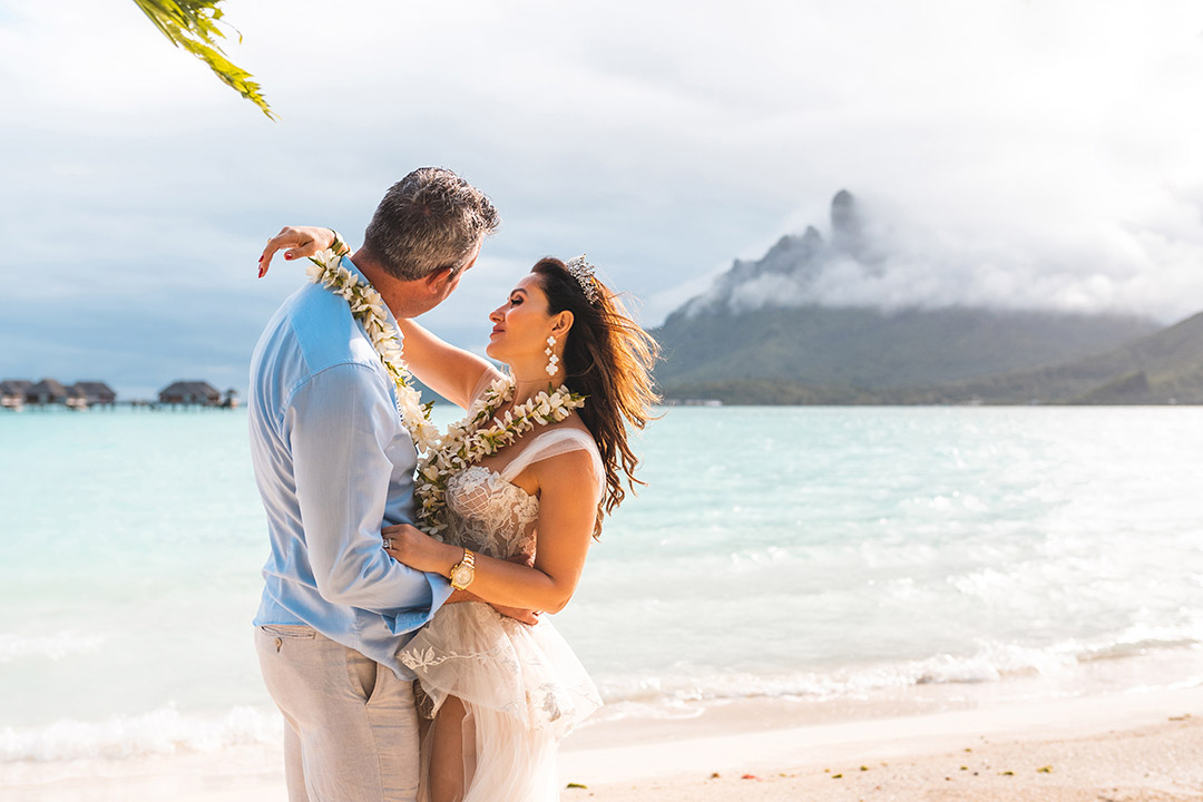 Photographe de mariage au Four Seasons Bora Bora - Le couple s'enlace sur la plage