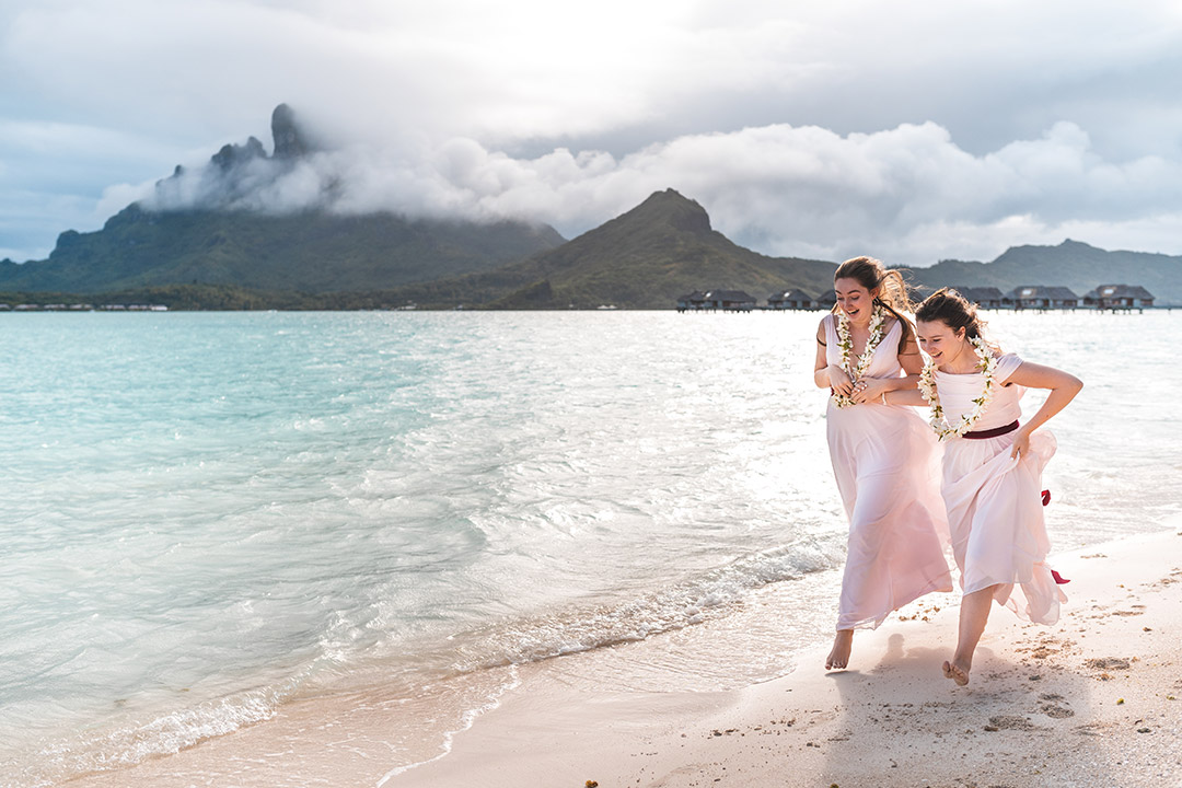 Photographe de mariage au Four Seasons Bora Bora - Les filles des mariées courent sur la plage